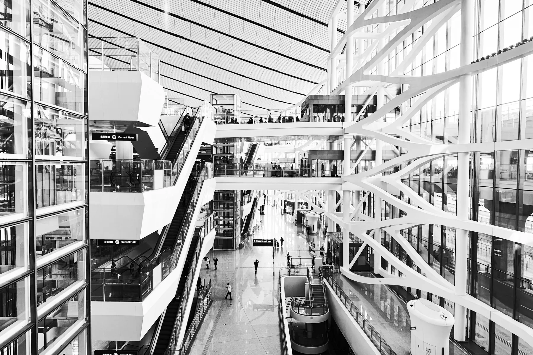 Travellers and escalators inside a modern Chinese airport terminal