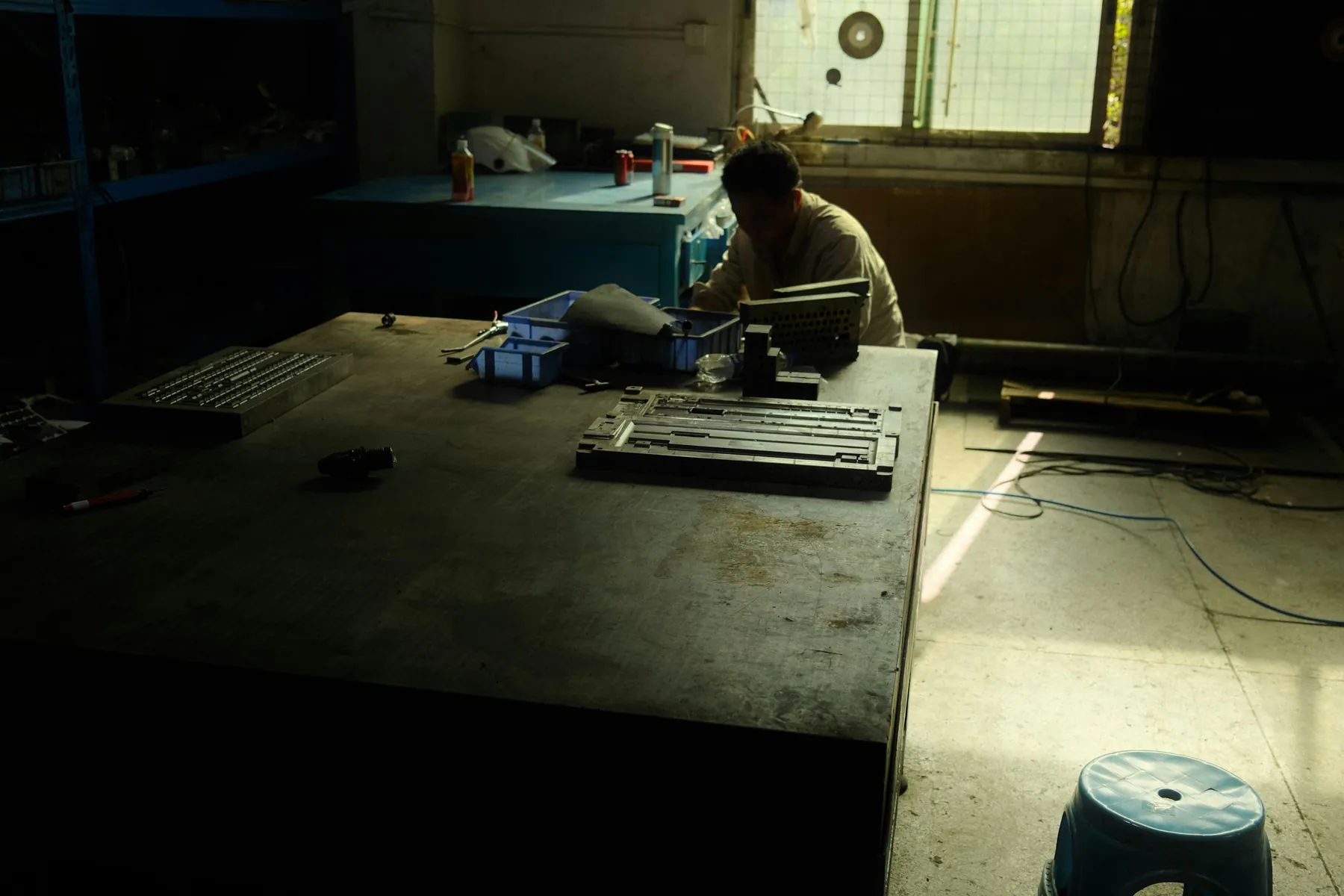 A worker concentrating at a tooling factory workbench in Dongguan